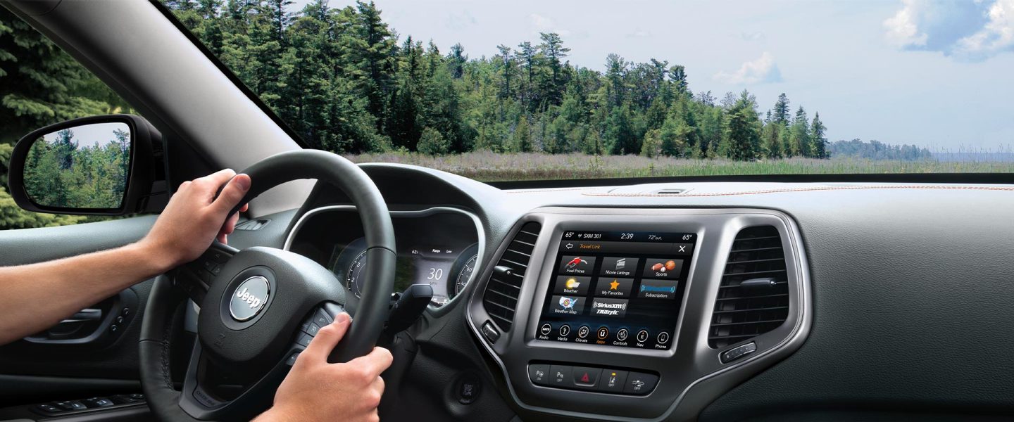 The steering wheel, instrument panel and Uconnect touchscreen on the 2020 Jeep Cherokee.