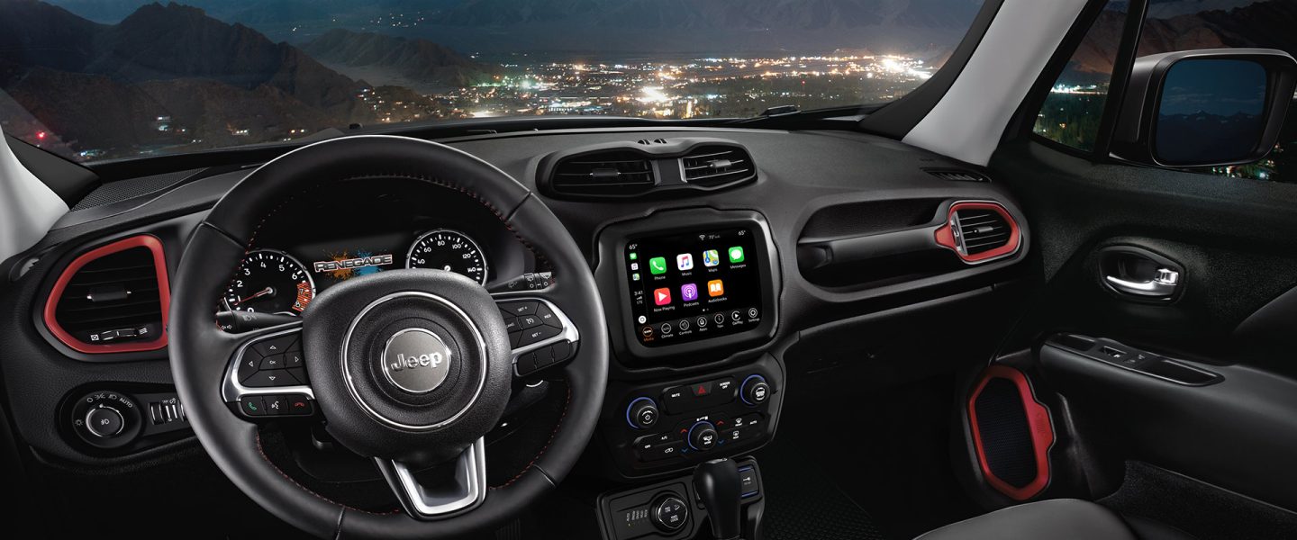 The cockpit of the 2020 Jeep Renegade focusing on the steering wheel, instrumentation, touchscreen and dash.