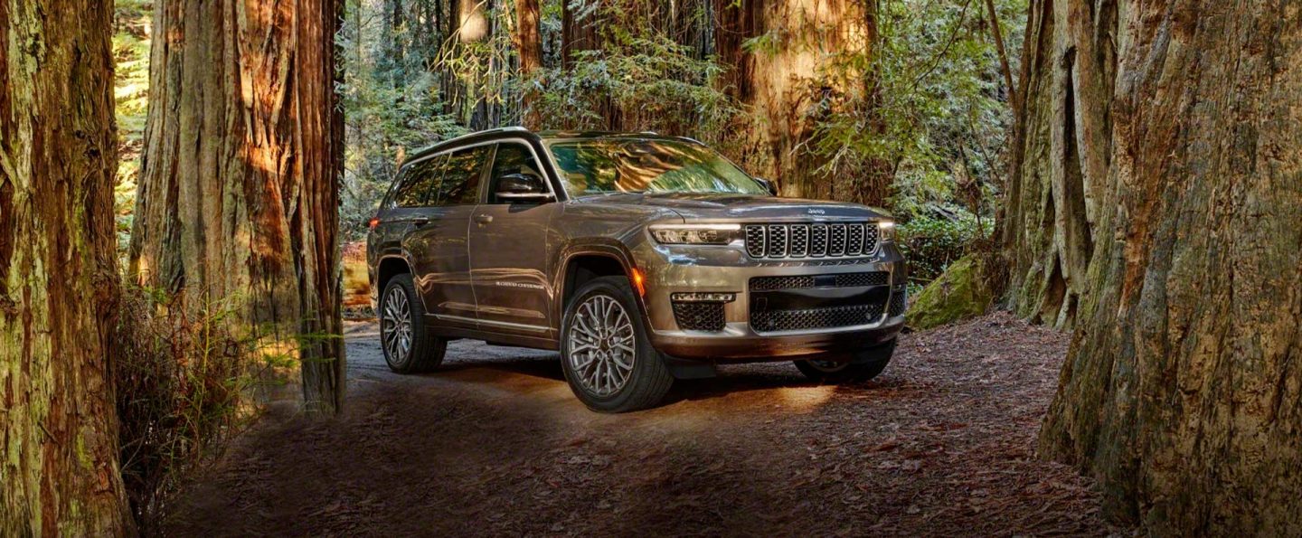 The 2021 Jeep Grand Cherokee L Summit Reserve parked off-road in a clearing in the woods.