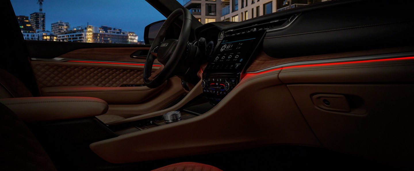 The interior ambient LED lighting system in the 2022 Jeep Grand Cherokee Summit Reserve, giving off a red glow.
