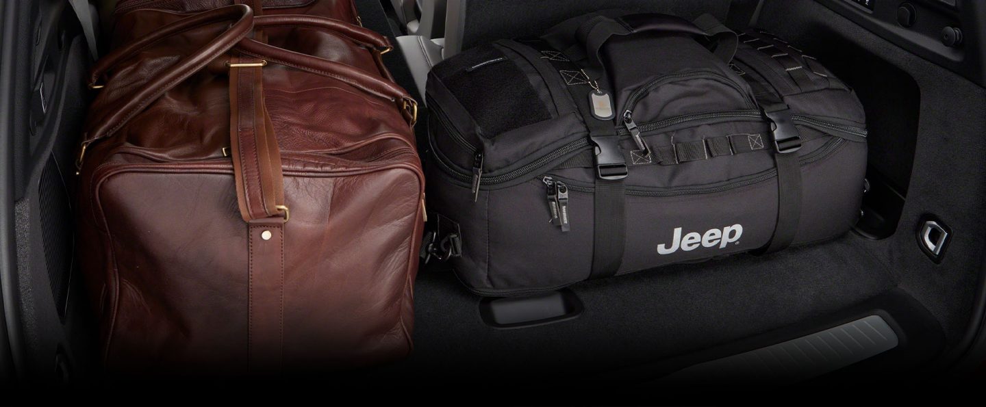 The cargo area of the 2022 Jeep Grand Cherokee with one of the third-row seats folded down to fit luggage.