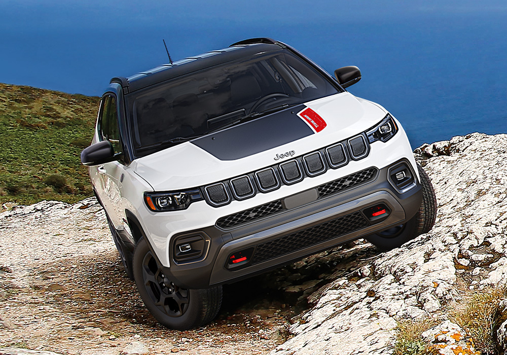 A 2023 Jeep Compass Trailhawk parked horizontally on a steep, rocky hill.