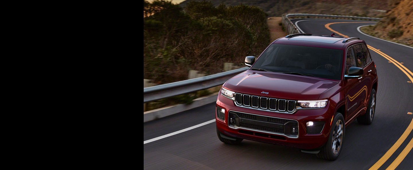 The 2023 Jeep Grand Cherokee Overland being driven on a winding road.