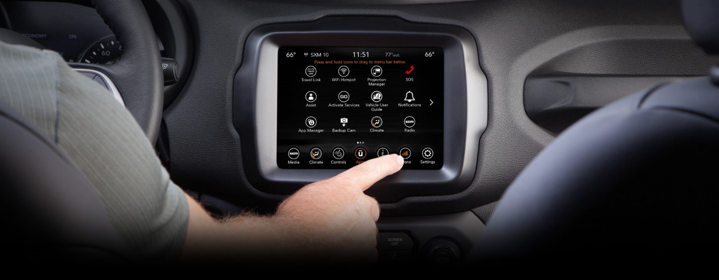 A close-up of the touchscreen in the 2023 Jeep Renegade with the driver's hand reaching for the phone icon on the screen.