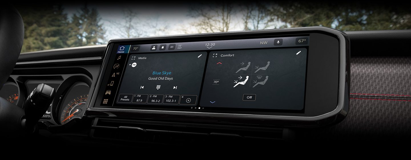 The Uconnect touchscreen in the 2024 Jeep Gladiator with a split screen displaying an audio selection on the left, and the climate controls on the right.